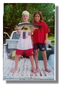 Hudson Wilson with his 7 1/2 lb bass caught from the pier on Lake Ely and his sister, Lauren (summer, 2001)